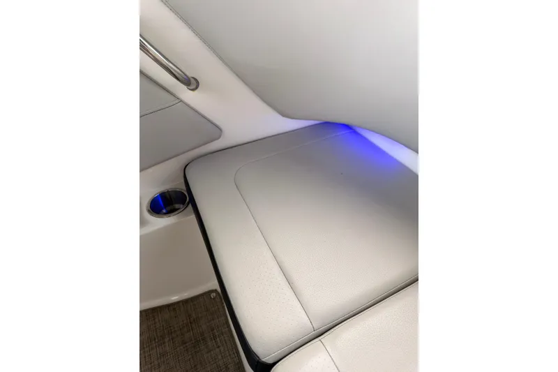 Slide: The Image of 2021 Sea Ray SPX 190 interior with cushioned seating and ambient blue lighting. - 30