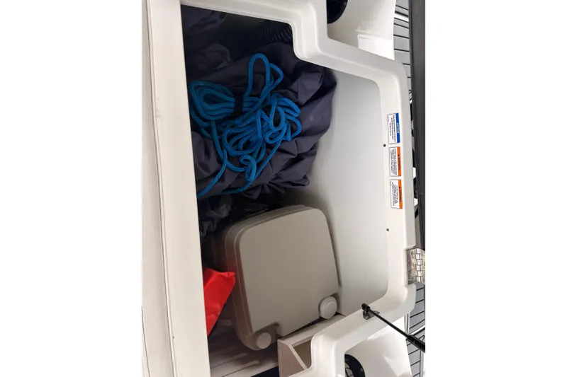 Slide: The Image of Storage compartment of a 2021 Sea Ray SPX 190 boat with blue rope and equipment. - 33