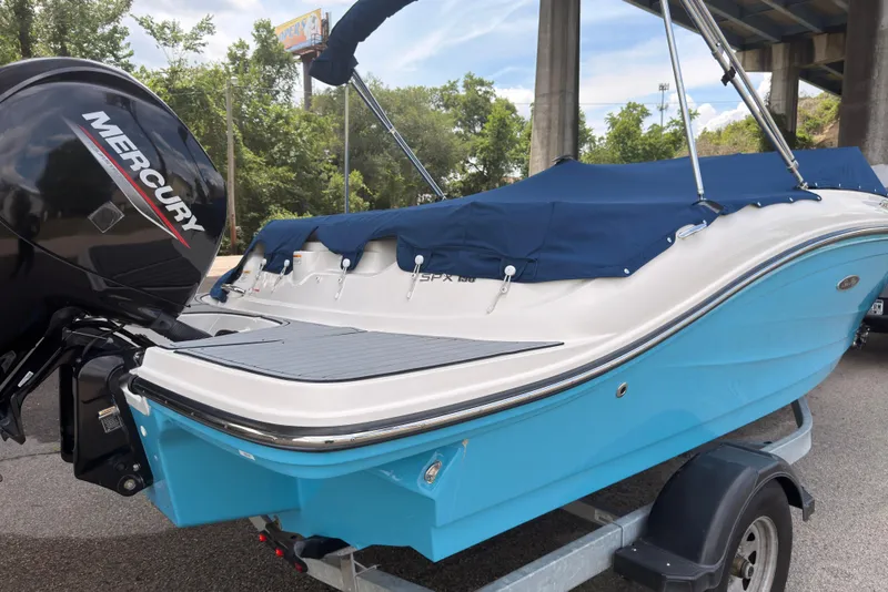 Slide: The Image of 2021 Sea Ray SPX 190 boat with Mercury engine, blue hull, and covered seating area. - 40