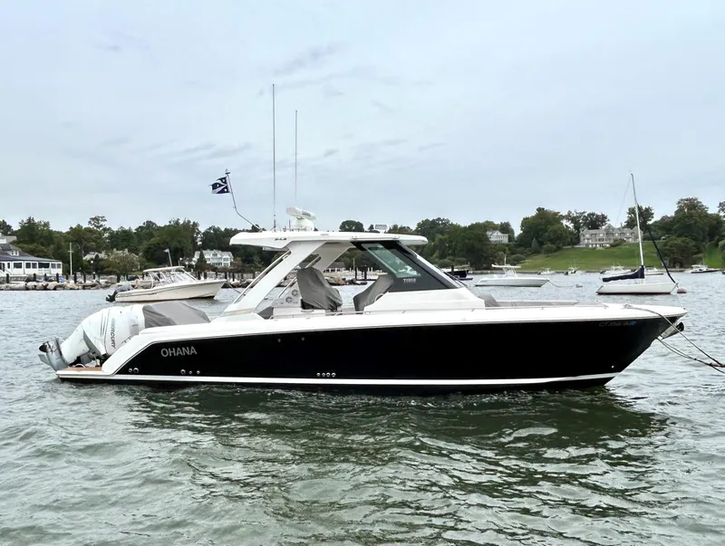 Slide: The Image of 2020 Tiara Sport 34 LS boat on a calm lake with scenic background. - 2
