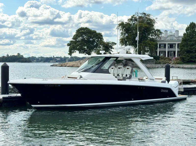Slide: The Image of 2020 Tiara Sport 34 LS boat docked on a scenic waterfront. - 28