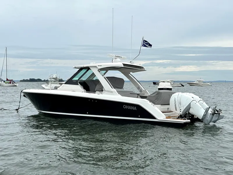 Slide: The Image of 2020 Tiara Sport 34 LS boat on water, side view, with "Ohana" name visible. - 6
