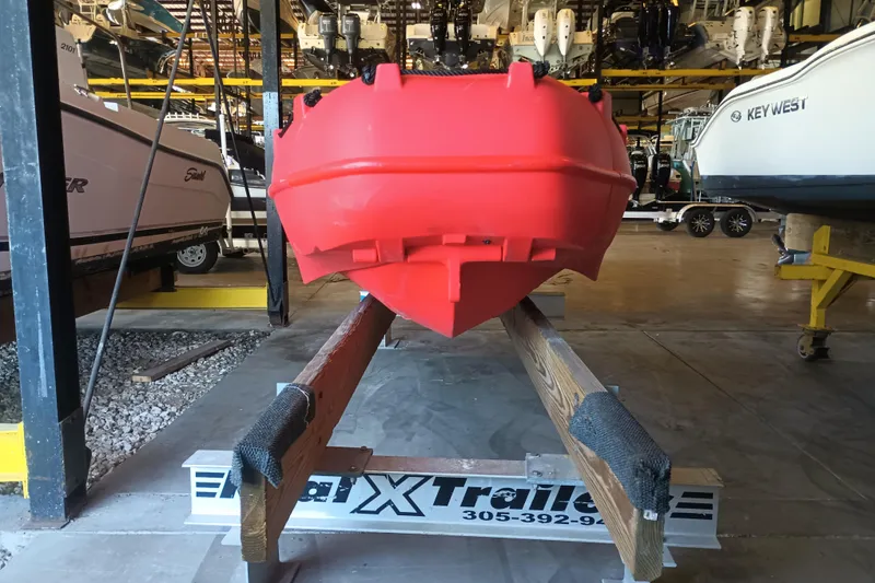 Slide: The Image of 2024 Whaly 455R boat in vibrant red on a trailer in a storage facility. - 1