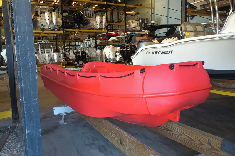 Slide: The Image of Red 2024 Whaly 455R boat in storage, surrounded by various other boats. - 2