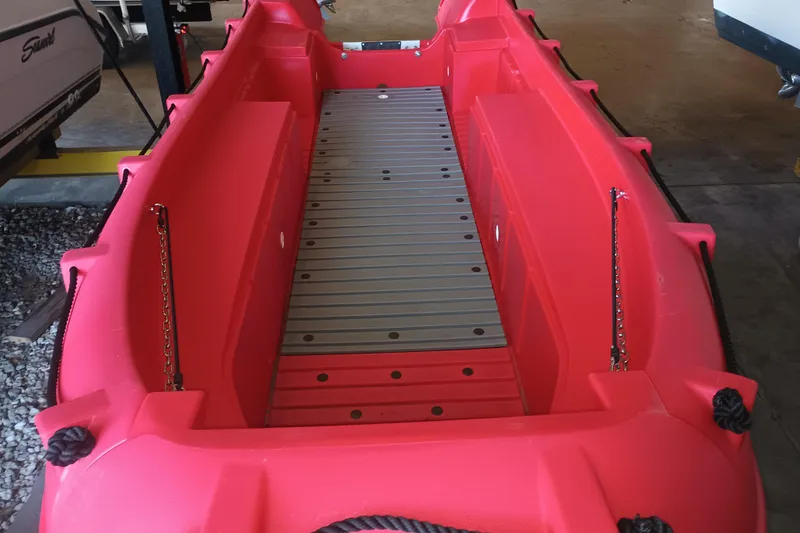 Slide: The Image of Red 2024 Whaly 455R boat interior with metal flooring, parked indoors. - 3