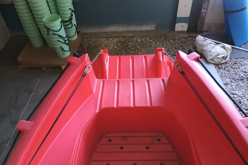 Slide: The Image of Red 2024 Whaly 455R boat interior in a storage area with stacked green items. - 4