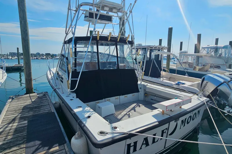 The Image of 1988 Rampage 31 Express boat docked at marina under clear blue sky. - 0