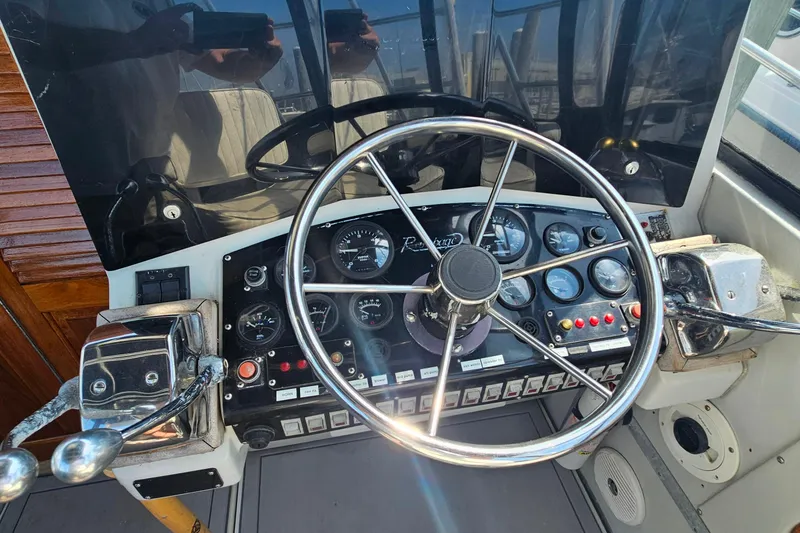 Slide: The Image of Cockpit of 1988 Rampage 31 Express boat with steering wheel and control panel. - 13