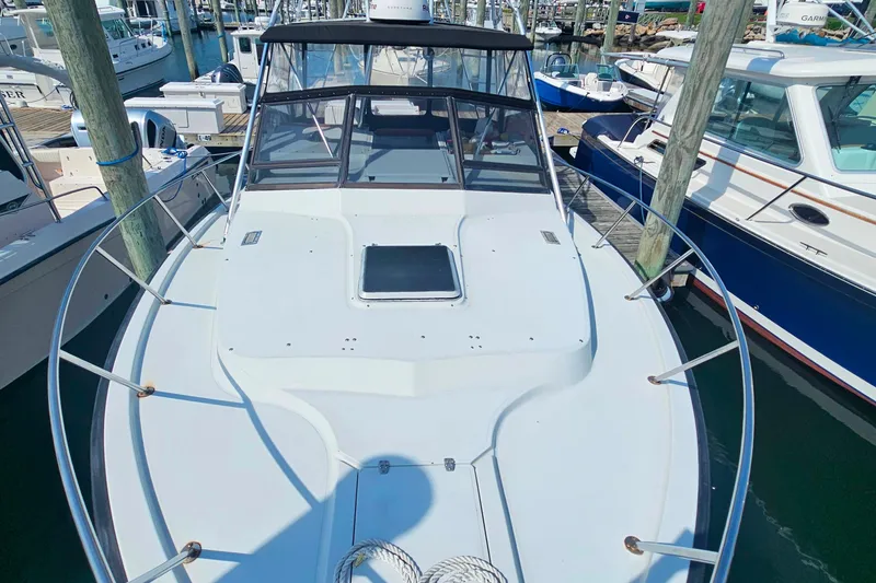 Slide: The Image of 1988 Rampage 31 Express boat docked at marina, showcasing spacious deck and sleek design. - 6