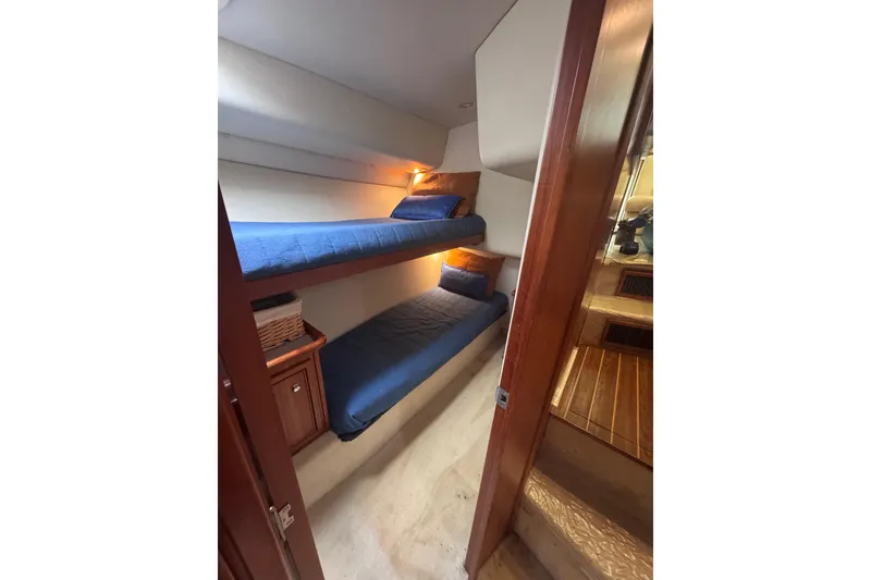 Slide: The Image of 2006 Riviera 37 Flybridge cabin with bunk beds and cozy lighting. - 20