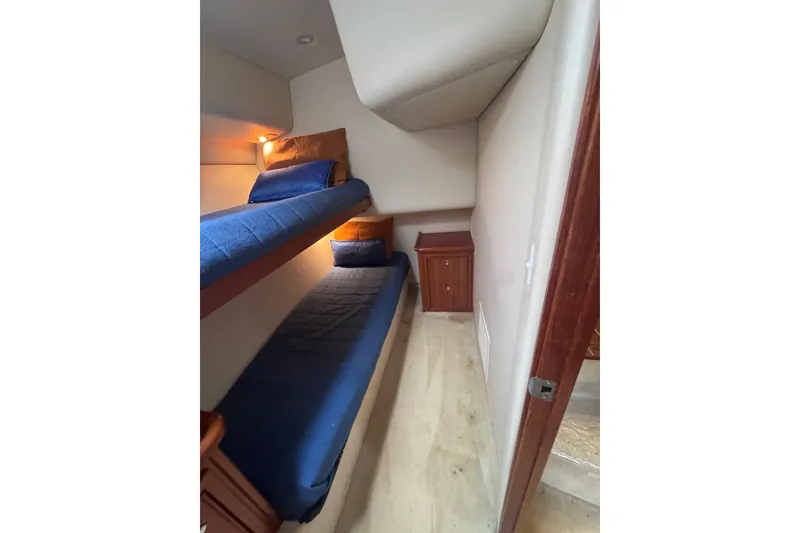 Slide: The Image of 2006 Riviera 37 Flybridge cabin with bunk beds and wooden cabinet. - 21