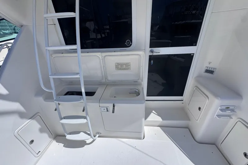 Slide: The Image of 2006 Riviera 37 Flybridge yacht interior with ladder, sink, and storage compartments. - 26