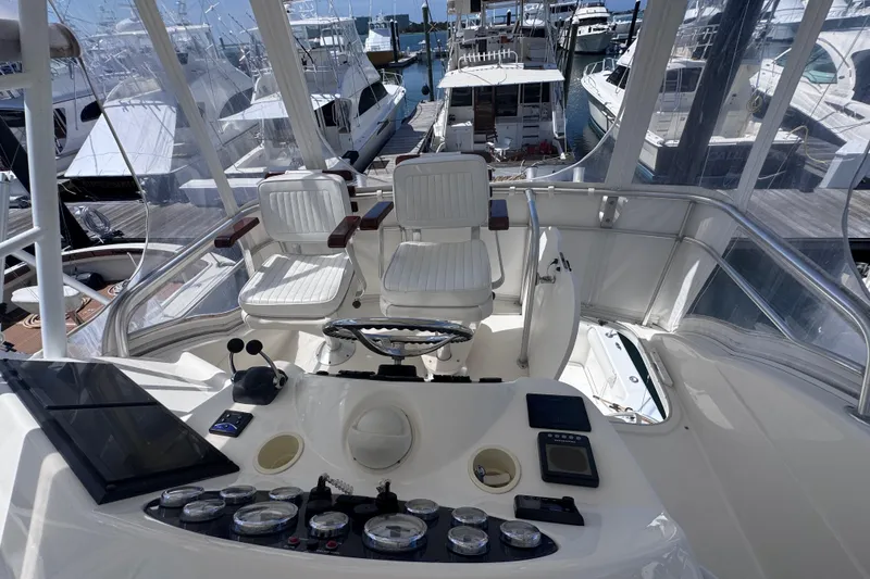 Slide: The Image of Flybridge of 2006 Riviera 37 yacht with helm controls and seating, docked at marina. - 29