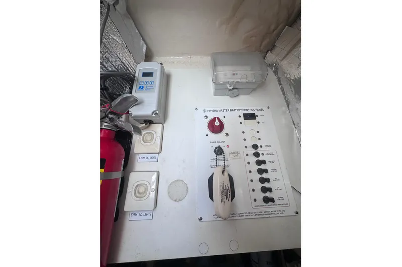 Slide: The Image of Control panel of a 2006 Riviera 37 Flybridge boat with switches and fire extinguisher. - 44