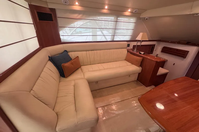 Slide: The Image of Luxurious interior of 2006 Riviera 37 Flybridge yacht with beige seating and wooden accents. - 7