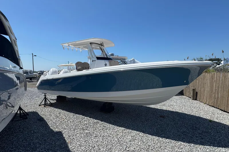 The Image of 2026 Edgewater 262CC boat displayed on gravel lot under clear blue sky. - 0