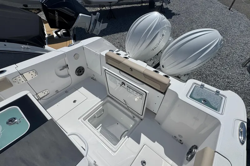 Slide: The Image of 2026 Edgewater 262CC boat deck with storage compartments and twin outboard engines. - 12