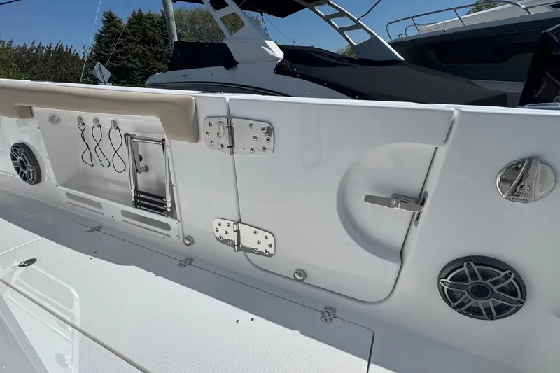 Slide: The Image of 2026 Edgewater 262CC boat interior with speakers, storage, and stainless steel fittings. - 13