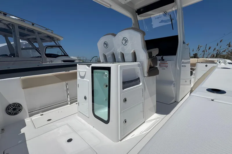 Slide: The Image of 2026 Edgewater 262CC boat interior with seating and storage compartments under a clear blue sky. - 21
