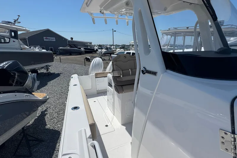 Slide: The Image of 2026 Edgewater 262CC boat at a marina, showcasing sleek design and spacious deck. - 34