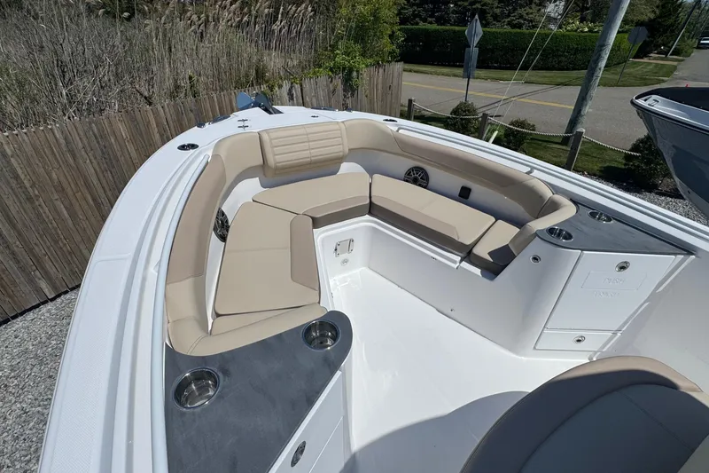 Slide: The Image of 2026 Edgewater 262CC boat with beige seating and cup holders, docked outdoors. - 39