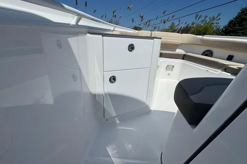 Slide: The Image of 2026 Edgewater 262CC boat interior with white storage compartments and beige seating. - 40