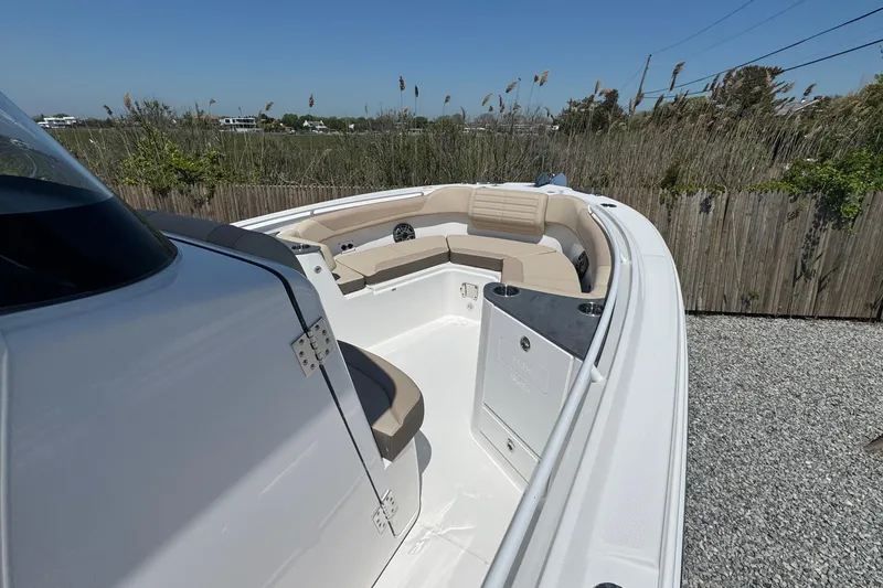 Slide: The Image of 2026 Edgewater 262CC boat interior with beige seating, sleek design, and outdoor setting. - 41