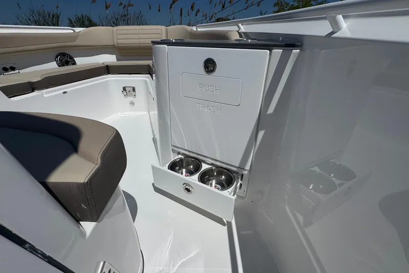 Slide: The Image of Interior of 2026 Edgewater 262CC boat featuring a built-in trash compartment and seating. - 44