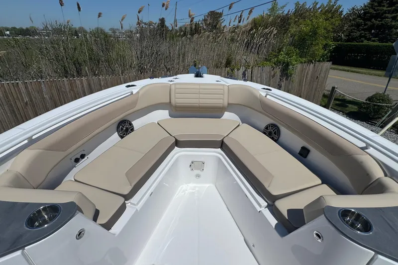 Slide: The Image of 2026 Edgewater 262CC boat with spacious seating and cup holders, surrounded by greenery. - 46
