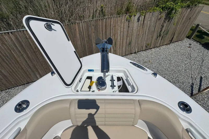 Slide: The Image of Open anchor compartment on 2026 Edgewater 262CC boat, showcasing storage and seating area. - 56