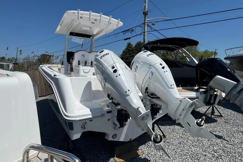 Slide: The Image of Edgewater 262CC 2026 with twin outboard engines on gravel lot. - 8