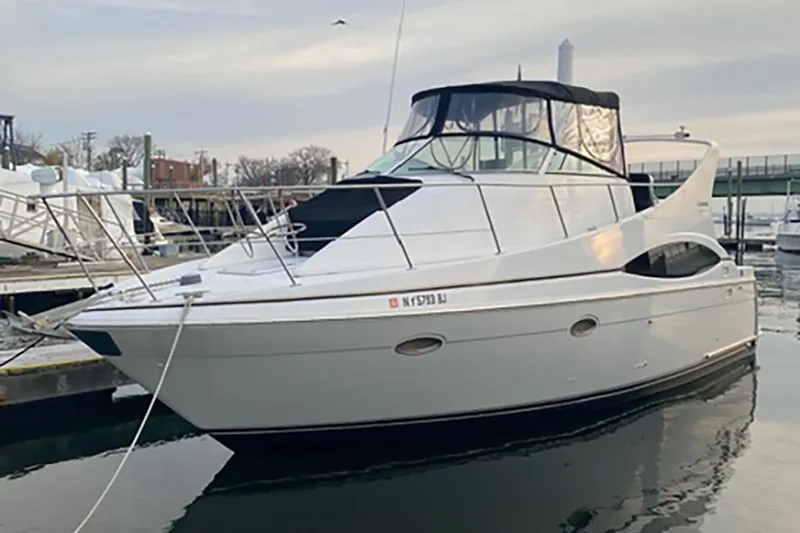 Slide: The Image of 2000 Carver 350 Mariner yacht docked at marina, featuring sleek design and spacious deck. - 1