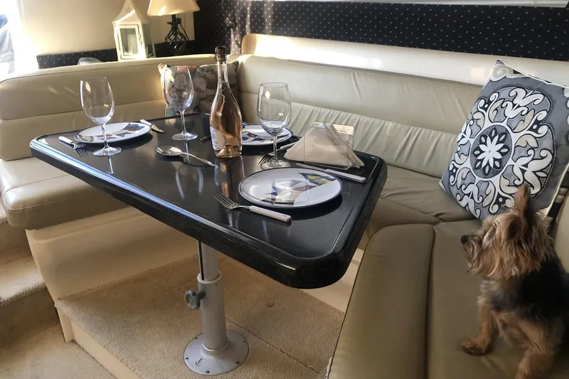 Slide: The Image of Luxurious dining setup on 2000 Carver 350 Mariner yacht with elegant tableware and cozy seating. - 16