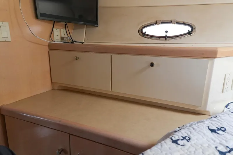 Slide: The Image of Interior of 2000 Carver 350 Mariner with cabinets, TV, and porthole window. - 24