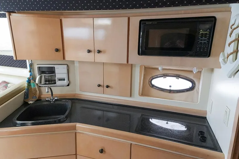 Slide: The Image of Compact kitchen in a 2000 Carver 350 Mariner yacht with microwave, sink, and stove. - 29