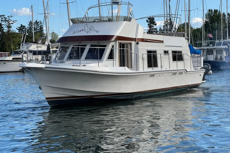 The Image of 1984 Uniflite YACHTHOME cruising in a marina, surrounded by other boats. - 0