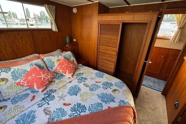 Slide: The Image of 1984 Uniflite YACHTHOME bedroom with nautical-themed bedding and wooden interior. - 10