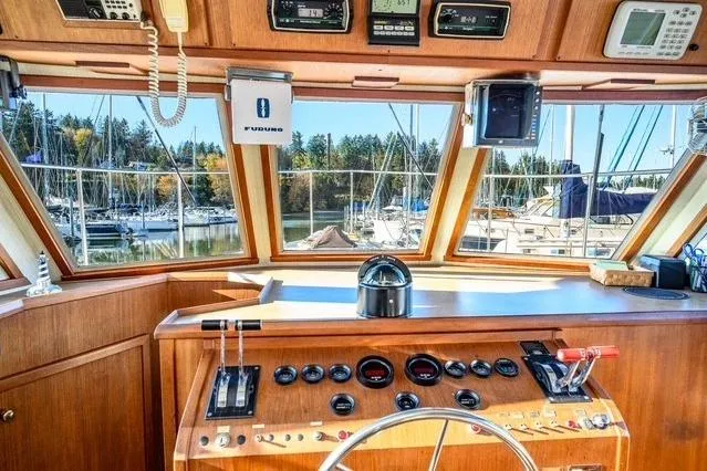 Slide: The Image of 1984 Uniflite YACHTHOME helm with navigation instruments and marina view. - 13
