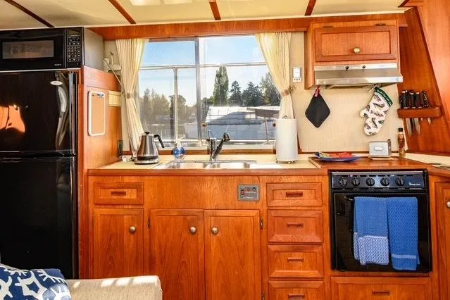 Slide: The Image of 1984 Uniflite YACHTHOME kitchen with wooden cabinetry, appliances, and window view. - 16