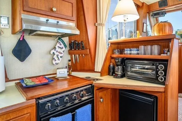 Slide: The Image of 1984 Uniflite YACHTHOME kitchen with stove, oven, and wooden cabinetry. - 17