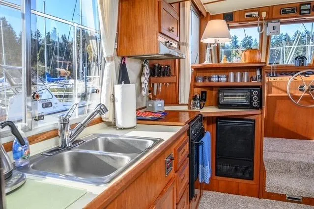 Slide: The Image of 1984 Uniflite YACHTHOME kitchen interior with sink, appliances, and wooden cabinetry. - 18