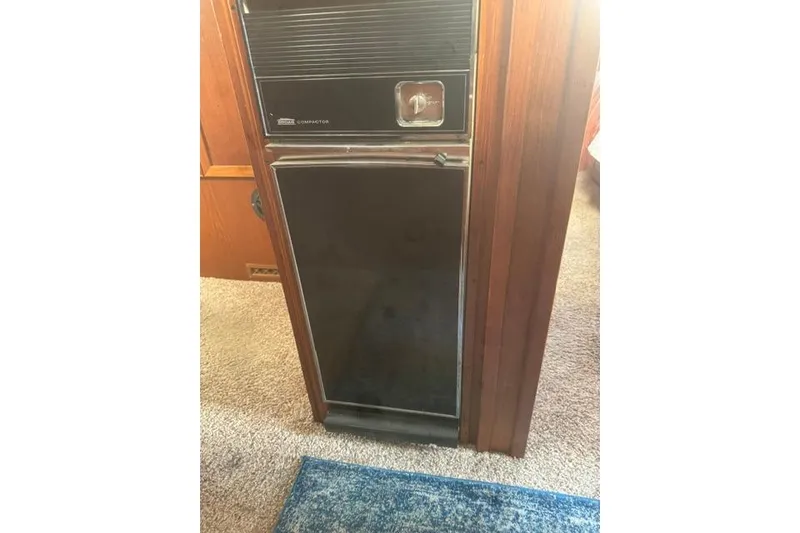 Slide: The Image of 1984 Uniflite YACHTHOME interior with vintage trash compactor and wood paneling. - 21