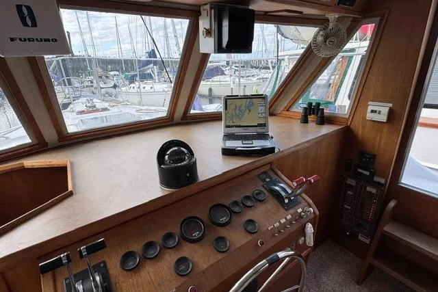 Slide: The Image of 1984 Uniflite YACHTHOME helm with navigation equipment and marina view. - 24
