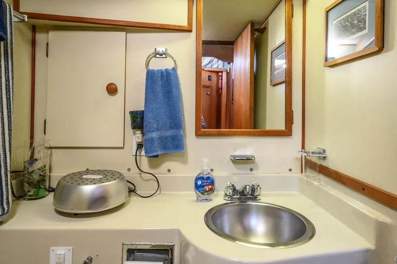 Slide: The Image of 1984 Uniflite YACHTHOME bathroom with sink, mirror, and blue towel. - 27