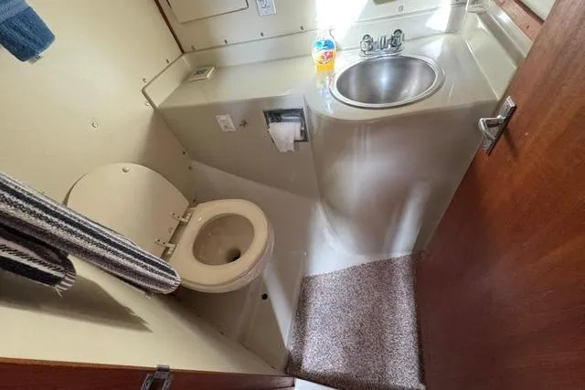 Slide: The Image of 1984 Uniflite YACHTHOME bathroom with toilet, sink, and towel. - 28
