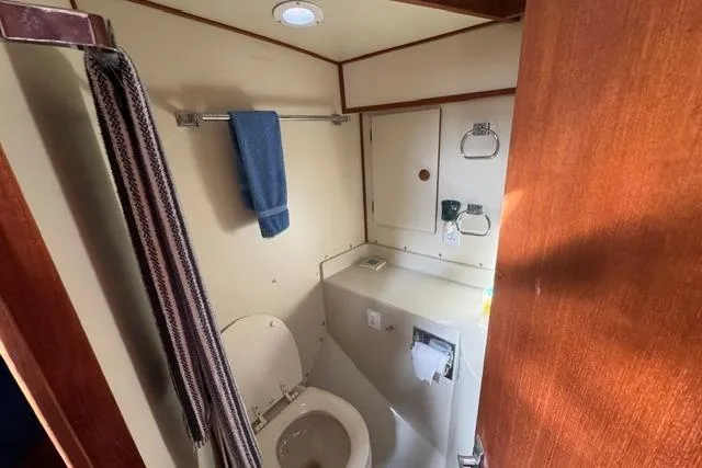 Slide: The Image of 1984 Uniflite YACHTHOME bathroom with toilet, towel, and storage cabinets. - 29