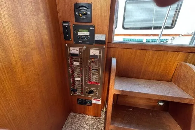 Slide: The Image of 1984 Uniflite YACHTHOME electrical panel with wooden interior and stairs. - 30