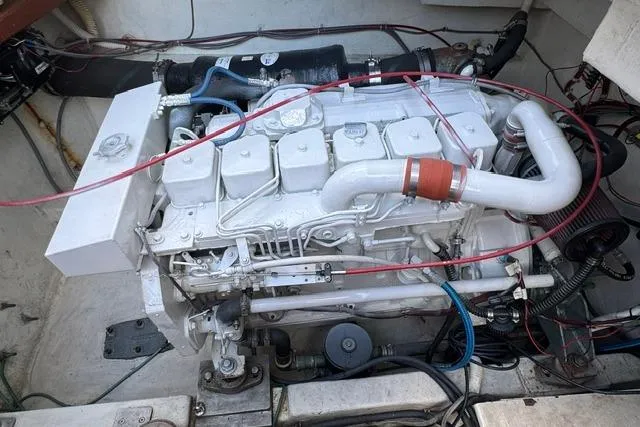 Slide: The Image of Engine compartment of a 1984 Uniflite YACHTHOME, showcasing a clean, well-maintained marine engine. - 32