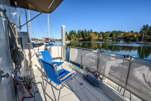 Slide: The Image of 1984 Uniflite YACHTHOME deck with blue chairs overlooking serene marina. - 4