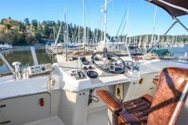 Slide: The Image of 1984 Uniflite YACHTHOME helm with marina view, featuring classic controls and seating. - 5